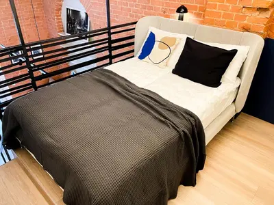 a bed in a room with a brick wall at thePilots in Kaunas
