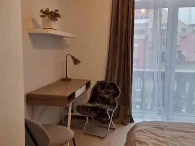 a bedroom with a desk and a chair and a window at Refurbished central apartment in Vilnius