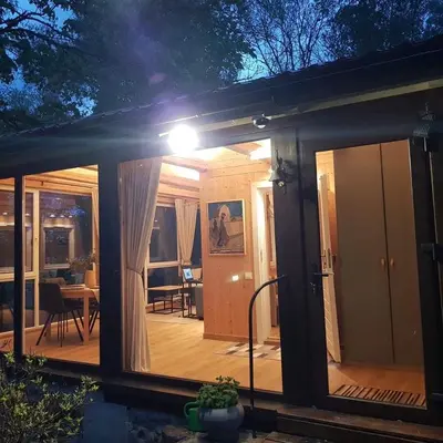 a house with a large glass door with a patio at Svedaso Lake House with Sauna in Svėdasai