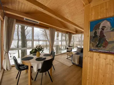 a living room with a table and a couch at Svedaso Lake House with Sauna in Svėdasai