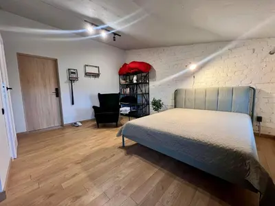 a bedroom with a bed and a chair in it at Apartamentai Kauno centre in Kaunas