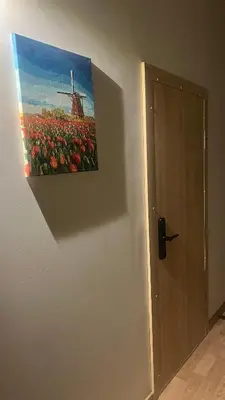 a painting of a farm with a windmill on a wall at Apartamentai Kauno centre in Kaunas