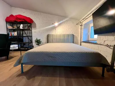 a bedroom with a bed and a brick wall at Apartamentai Kauno centre in Kaunas