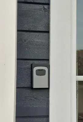 a black door with a box on the side of it at Apgyvendinimas Rokiskyje namukas Skandis in Rokiškis