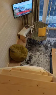 a living room with a couch and a tv at Apgyvendinimas Rokiskyje namukas Skandis in Rokiškis