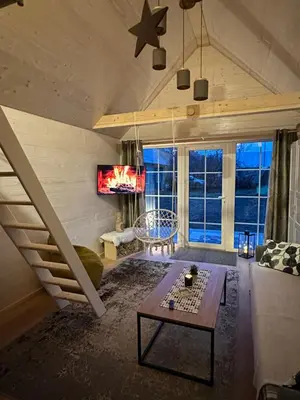 a living room with a staircase and a couch at Apgyvendinimas Rokiskyje namukas Skandis in Rokiškis