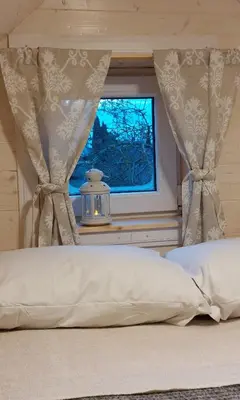 a bed in a bedroom with a window at Apgyvendinimas Rokiskyje namukas Skandis in Rokiškis
