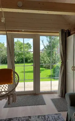 a porch with sliding glass doors and a swing at Apgyvendinimas Rokiskyje namukas Skandis in Rokiškis