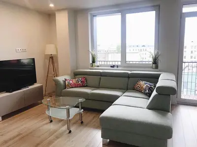 a living room with a couch and a tv at Brand New! 2Bdr 70m2 Old Town in Vilnius