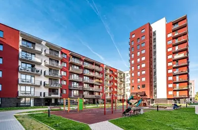 a playground in a park next to tall buildings at Brand New! 2Bdr 70m2 Old Town in Vilnius