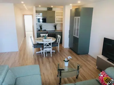 a living room with a table and a kitchen at Brand New! 2Bdr 70m2 Old Town in Vilnius