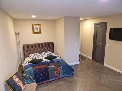 a bedroom with a bed and a flat screen tv at Petite City Centre Apartment self-check-in in Šiauliai