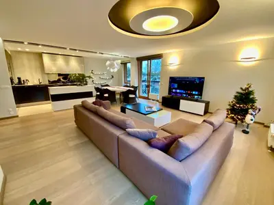 a living room with a large couch and a christmas tree at West Side Druskininkai in Druskininkai