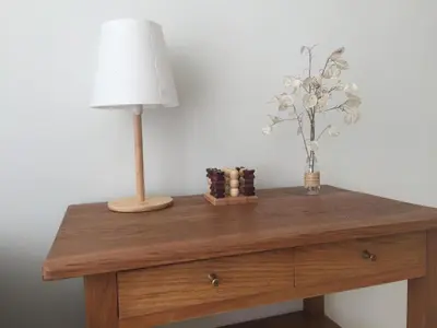 a table with a lamp and a vase of flowers on it at Močiutės apartamentai in Anykščiai