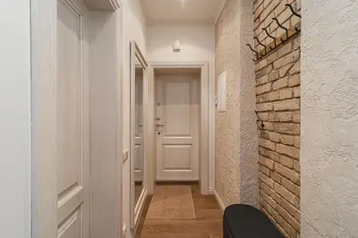 a hallway with a white door and a brick wall at Old Town Apartment on quiet private street in Vilnius