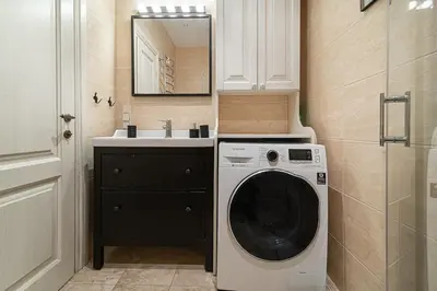 a bathroom with a washing machine and a sink at Old Town Apartment on quiet private street in Vilnius