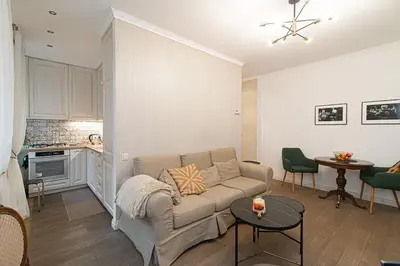 a living room with a couch and a kitchen at Old Town Apartment on quiet private street in Vilnius