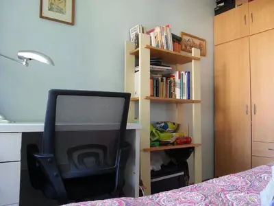 a tv sitting in a chair next to a book shelf at Lovely room in a centrally located flat in Vilnius