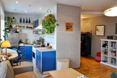 a kitchen and living room with blue cabinets at Lovely room in a centrally located flat in Vilnius