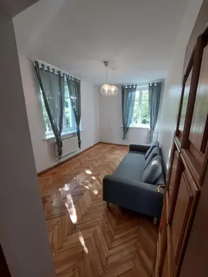 a living room with a couch and two windows at Treniotos Apartamentai in Vilnius