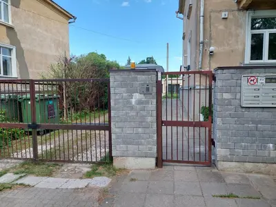 a fence with a gate in front of a house at Treniotos Apartamentai in Vilnius