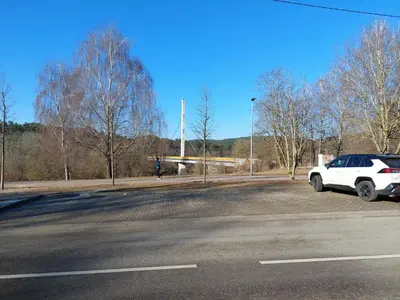 a white car parked on the side of a parking lot at Treniotos Apartamentai in Vilnius