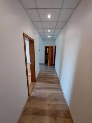 a hallway of an empty room with white walls and wooden floors at Treniotos Apartamentai in Vilnius