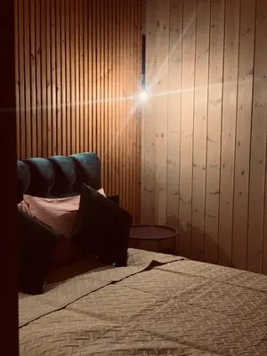 a bedroom with a bed and a blue couch at Aurora Resort in Stasiūnai