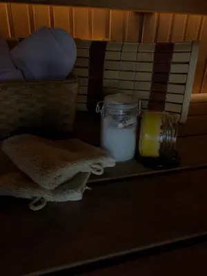 a shelf with a jar and a candle and towels at Aurora Resort in Stasiūnai