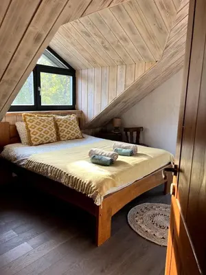 a bedroom with a large bed in a attic at Kaimukas - lake house for 15 persons 5 bedrooms in Dvarčėnai