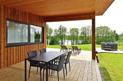 a patio with a table and chairs and a grill at Lamėsto Krantas in Saldutiškis