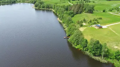 an aerial view of a river with a house on the shore at Lamėsto Krantas in Saldutiškis