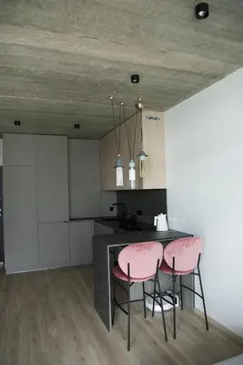 a kitchen with two pink chairs and a table at Ralio apartamentai monkey in Vilnius