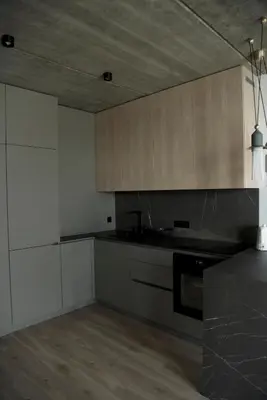 a kitchen with white cabinets and a black counter top at Ralio apartamentai monkey in Vilnius