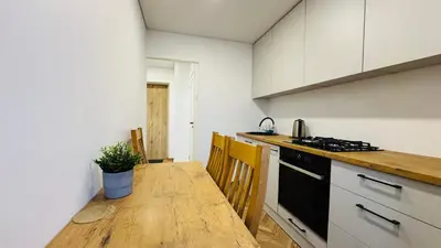 a kitchen with a wooden table and a counter top at Light of Happiness in Anykščiai