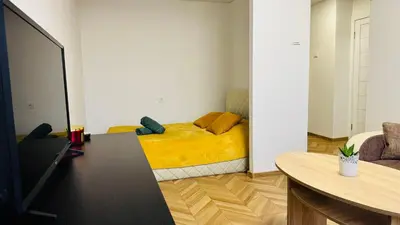 a bedroom with a yellow bed in a room at Light of Happiness in Anykščiai