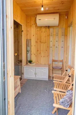 a bathroom with wooden walls and a sink and a mirror at Poilsio oazė in Panevėžys
