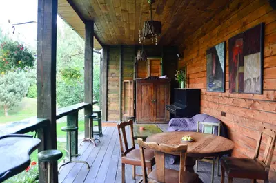 a wooden porch with a wooden table and chairs at Gallery Guest Rooms in Kernavė
