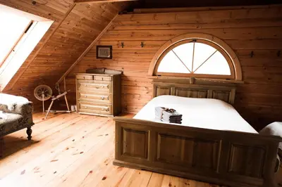 an attic bedroom with a bed and a window at Pakaso sodyba, šiaurinė pusė in Kirdeikiai