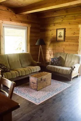 a living room with a couch and a coffee table at Pakaso sodyba, šiaurinė pusė in Kirdeikiai