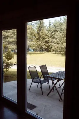 a view of a table and chairs from a window at Pakaso sodyba, šiaurinė pusė in Kirdeikiai