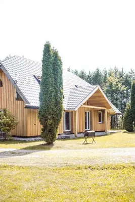 a wooden house with a bench in front of it at Pakaso sodyba, šiaurinė pusė in Kirdeikiai