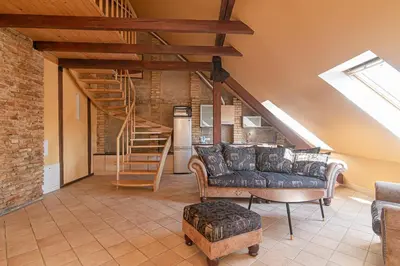 a living room with a couch and a staircase at Apartment with Sauna in Vilnius