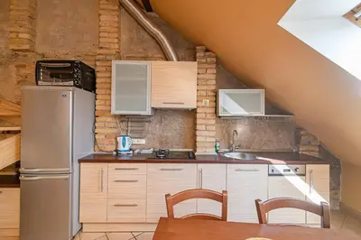 a kitchen with a refrigerator and a table with chairs at Apartment with Sauna in Vilnius