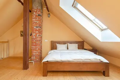 a bedroom with a bed in a loft at Apartment with Sauna in Vilnius