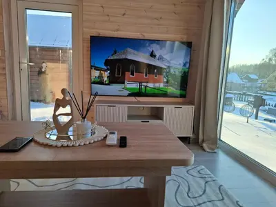 a living room with a tv and a wooden table at TORA nameliai in Aukštadvaris