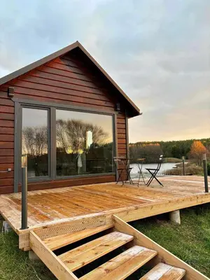 a wooden deck with a view of a house at TORA nameliai in Aukštadvaris