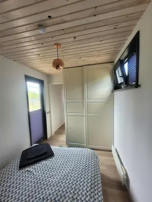 a bedroom with a bed and a wooden ceiling at Tiny House in Alytus