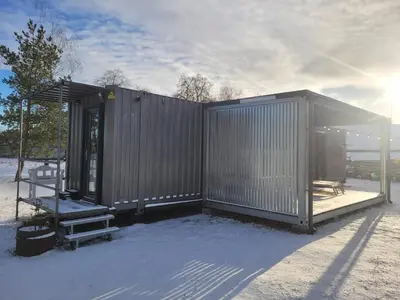 a small metal building with a bench and a table at Tiny House in Alytus