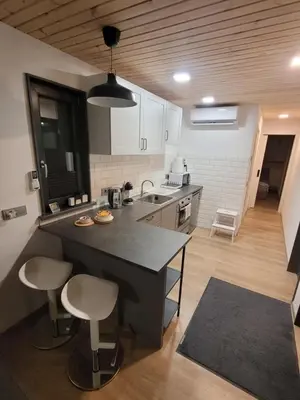 a kitchen with a black counter and stools in it at Tiny House in Alytus